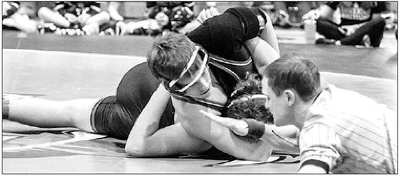 Grayson Jacobs watches the ref for the signal while he wrestles Thomas Halverson of Howard.