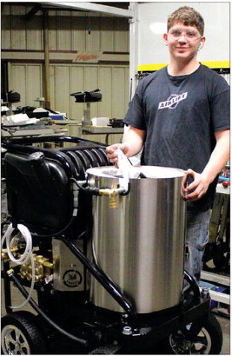Noah Thooft works on the cylinder to the pressure washer. He then used a hoist to lift it into place and put the finishing touches on the product. Photo by Beth Sherard-Hutcheson times1reporter@gmail.com