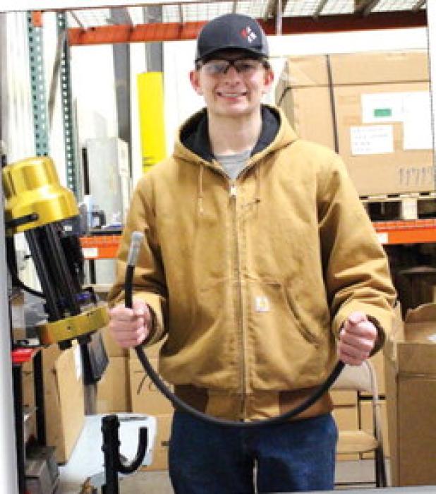 Hunter Sharkey shows off one of the hoses he made to be used for one of the products.