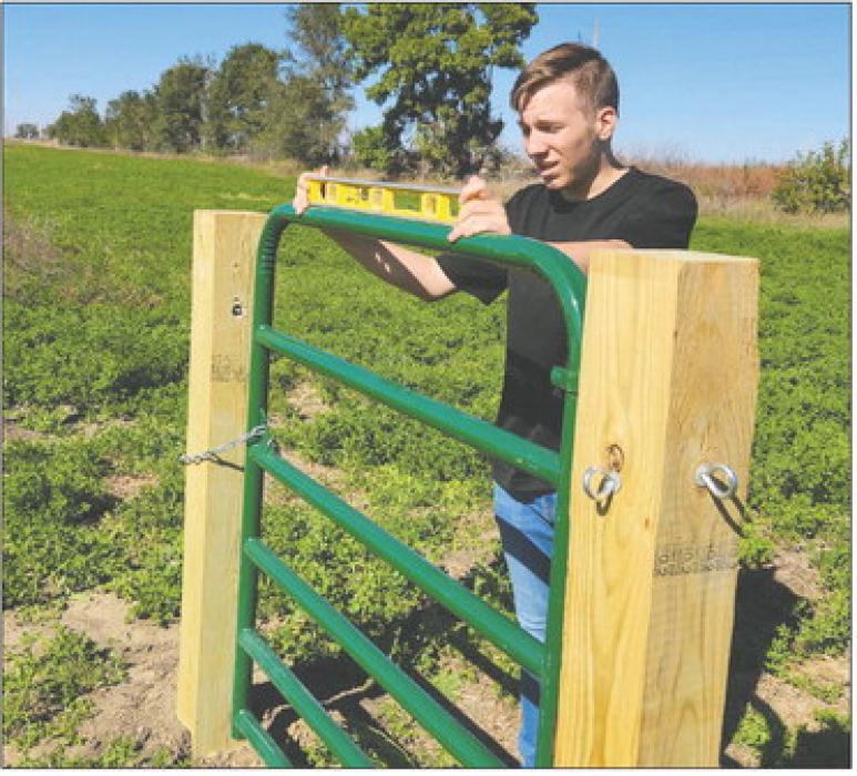 Keenan is seen here leveling a gate for his archery range project for the Tri-State Youth Association. Submitted photo